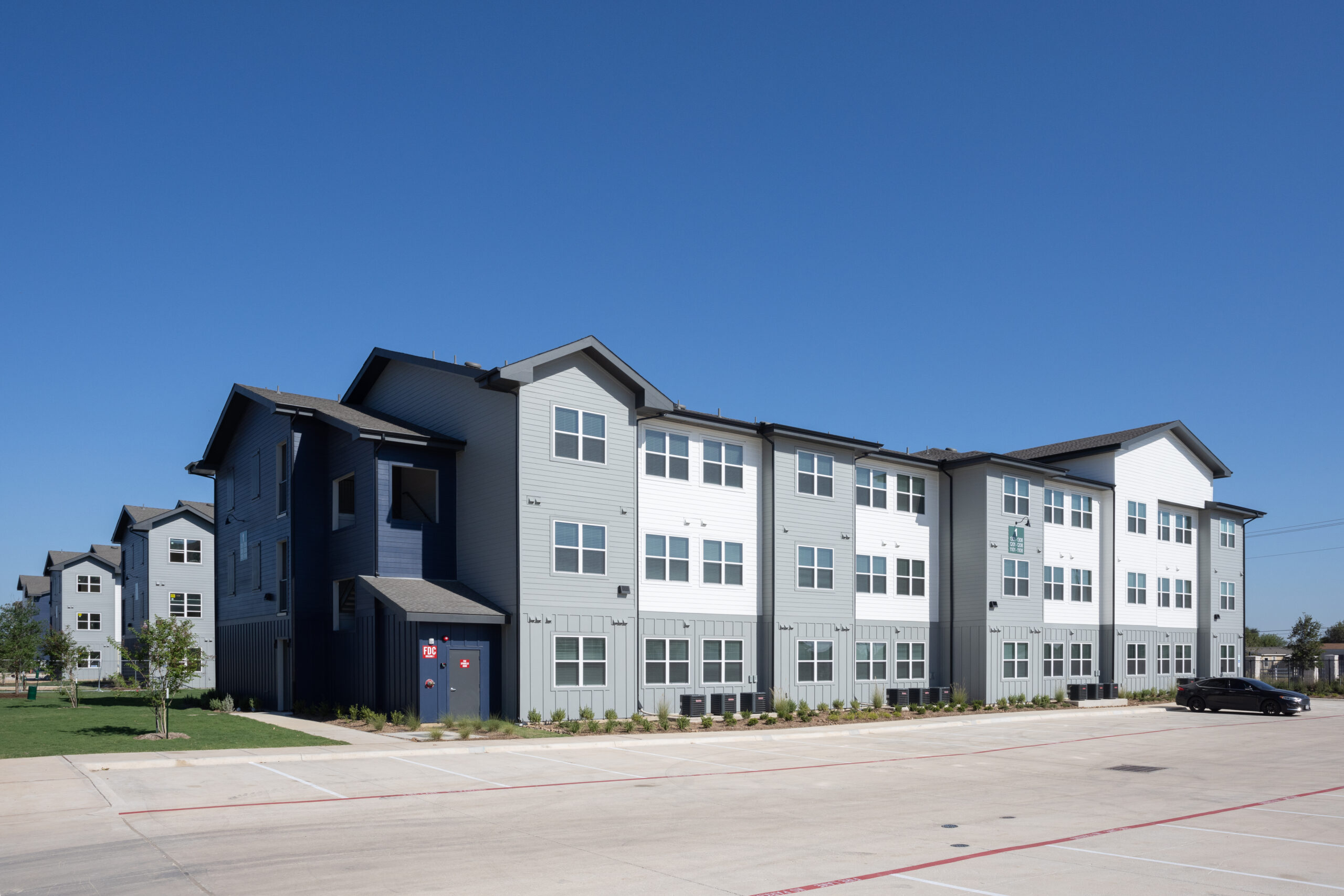 exterior of building showing two toned paint colors and a black car parking in the parking lot at prose evergreen in new braunfels, tx